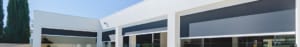 Motorized Outdoor Zipblind zip track outdoor shade screens installed on modern white residential building facade