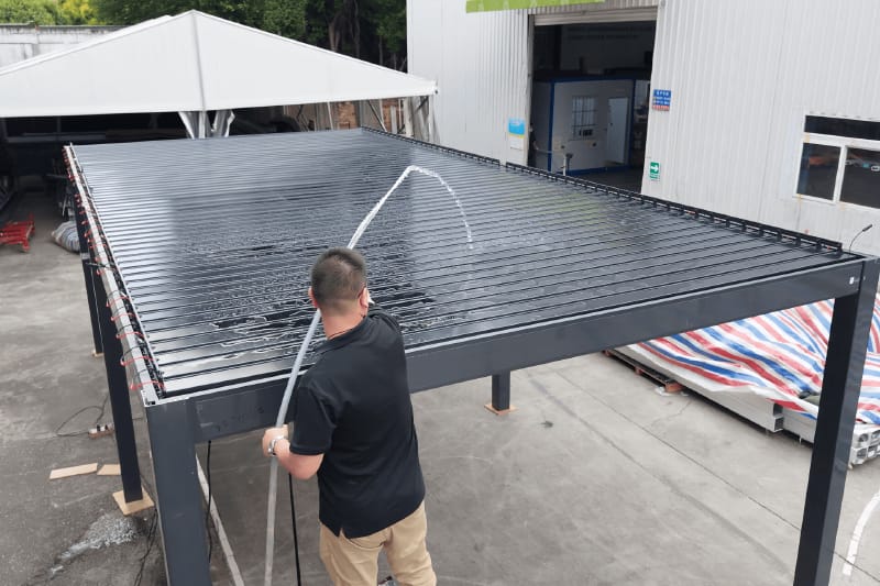 Factory water-flow test on an aluminum louvered pergola drainage system