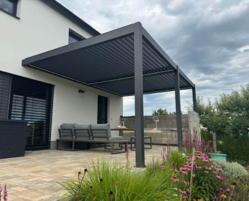 Dark grey motorized aluminum louvered pergola with LED strip lighting for European residential backyard garden patio
