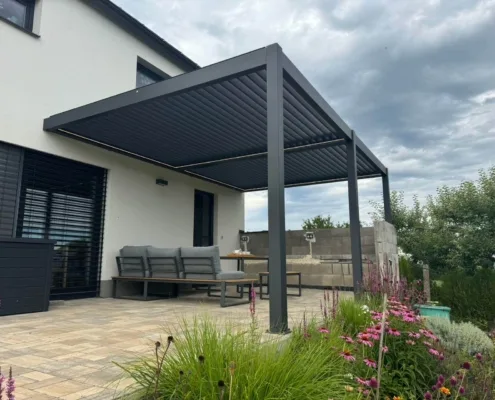 Dark grey motorized aluminum louvered pergola with LED strip lighting for European residential backyard garden patio