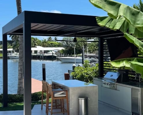 Black motorized aluminum louvered pergola for waterfront home outdoor BBQ bar entertainment space