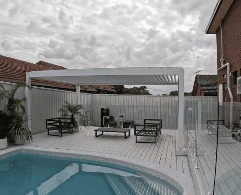 White motorized aluminum pergola louver roof for pool‑side outdoor lounge and relaxation area